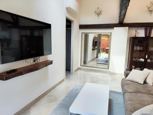 a living room with a couch and a tv on a wall at Ca' Mazzega in Murano