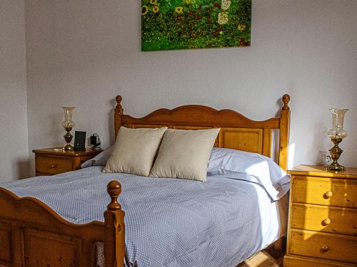 a bedroom with a wooden bed with two dressers and a painting at Live Adeje Ifonche Relax Place with Terrace in Adeje