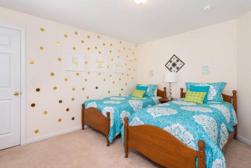 - 2 lits dans une chambre aux murs bleus et jaunes dans l'établissement Fun & Fabulous Getaway, à Gilford