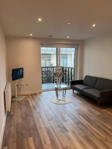 a living room with a couch and a tv at Beautiful one-bed in White City! in London