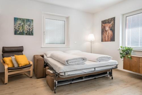 una habitación de hospital con 2 camas y una silla en Talhaus - Rita, en Ponte Nova