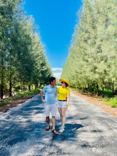 a man and a woman walking down a road at Minh Chau Beach Resort in Quang Ninh
