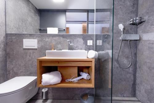 a bathroom with a sink and a shower at Landhaus Boutique Motel - contactless check-in in Nendeln