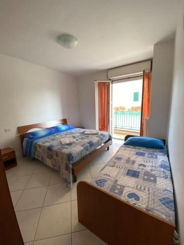 - une chambre avec 2 lits et une grande fenêtre dans l'établissement La casa al mare di Mary - Bilocale, à Roseto degli Abruzzi