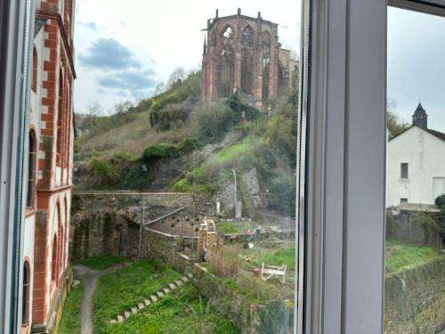a window with a view of a hill with a castle at Hotel-Café-Burg Stahleck in Bacharach