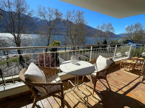 a balcony with a table and chairs and a view of the water at Minusio-Locarno Casa al Lago 1 in Minusio
