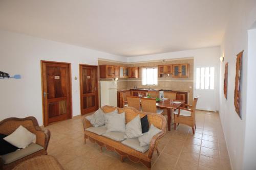 a living room with a couch and a dining room at Villa Sol e Mar - Vila do Maio - Ponta Preta in Vila do Maio