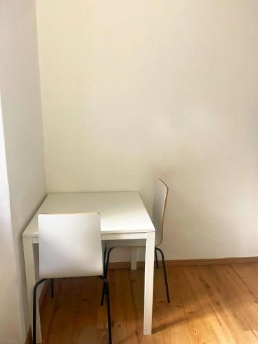 uma mesa branca e duas cadeiras num quarto em Piccolo appartamento nel cuore di Trieste em Trieste