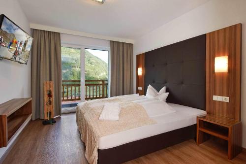 ein Schlafzimmer mit einem großen Bett und einem Balkon in der Unterkunft Alpen Diamond Top 500 in Sölden