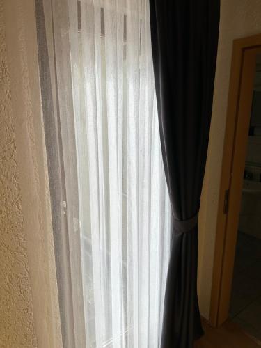 a window with white curtains and a black curtain at Hotel-Café-Burg Stahleck in Bacharach