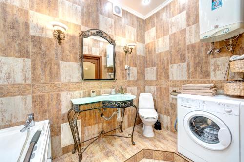 1-room VIP apartment in the Druzhby Narodiv metro station في كييف: حمام مع غسالة ملابس وغسالة ونشافة