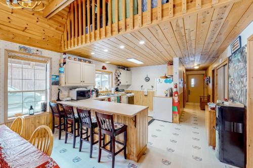 a kitchen with wooden ceilings and a counter with chairs at Crossfire Cabin in Cle Elum