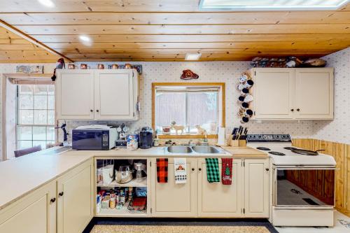 a kitchen with white cabinets and a sink at Crossfire Cabin in Cle Elum