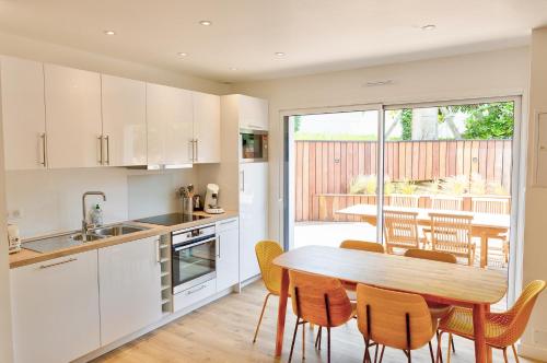 une cuisine et une salle à manger avec une table et des chaises dans l'établissement Port de Sainte-Marine : L'Îlot - Duplex & Terrasse, à Combrit