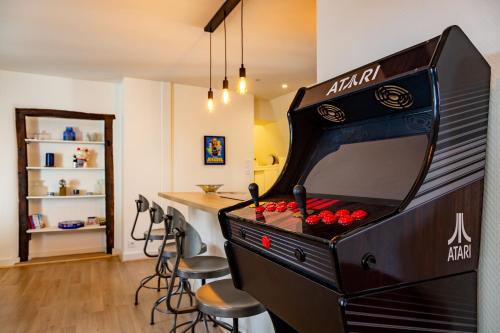 una máquina de ping pong con taburetes en una habitación en Happy Loft - Centre historique + parking privé, en Blois