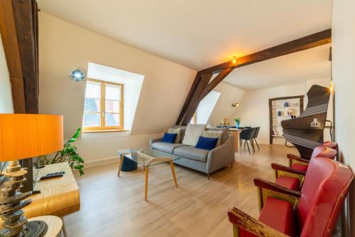 una sala de estar con un sofá y una mesa en Happy Loft - Centre historique + parking privé, en Blois