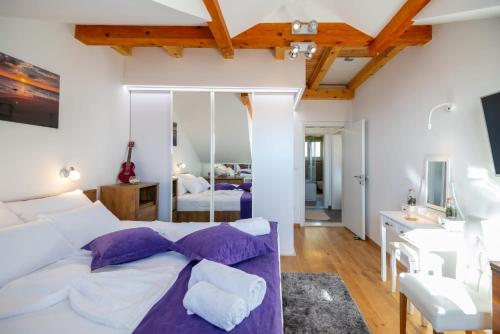 1 dormitorio con 1 cama blanca grande con almohadas moradas en Chiefs Suite - Kriste, en Dubrovnik