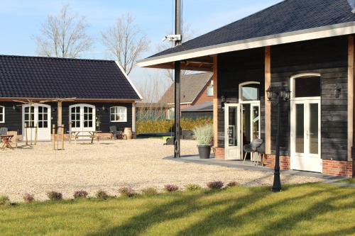 a building with a patio and a house with a yard at Noxem b&b in Boesingheliede