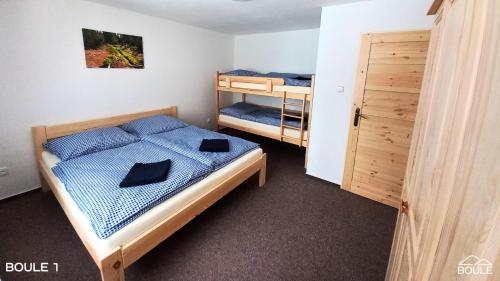 1 Schlafzimmer mit 2 Betten und 1 Etagenbett in der Unterkunft Apartmány Boule in Kovářská