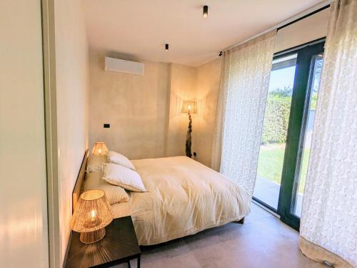 a bedroom with a bed and a large window at Villa Agapanto in Pacengo di Lazise