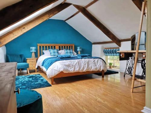 a bedroom with a bed and a blue wall at Penrallt-Fach Traditional Welsh cottage Pembrokeshire in Mynachlogddu