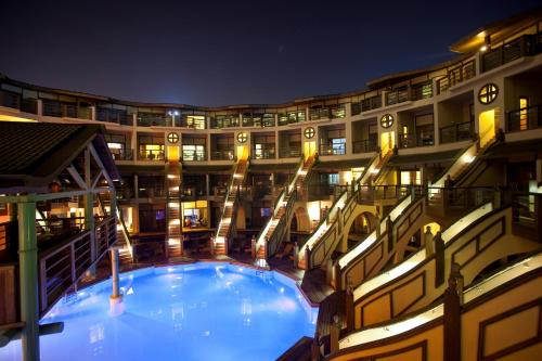 a large building with a large swimming pool at night at Limak Lara Deluxe Hotel & Resort Antalya in Lara