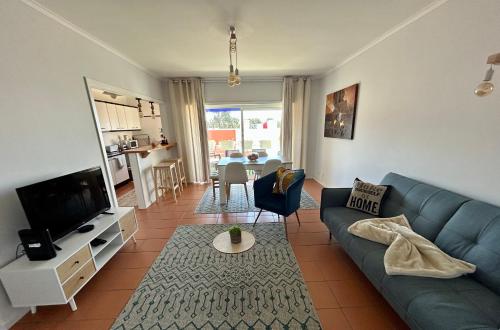 a living room with a blue couch and a tv at Divine Waves - Cabedelo in Viana do Castelo
