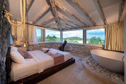 a bedroom with a large bed and a bath tub at K Bozcaada Revma in Bozcaada