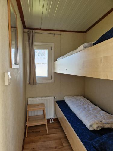a small bedroom with a bunk bed and a table at kreeft 171 in Ballum