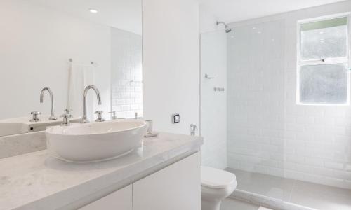 a white bathroom with a sink and a toilet at Tabas - Lindo apê 4 quartos na Lagoa RJ - LG0001 in Rio de Janeiro