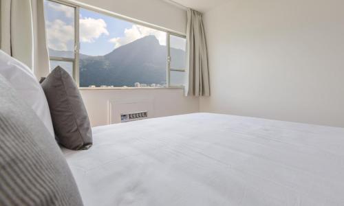 1 dormitorio con 1 cama y ventana grande en Tabas - Lindo apê 4 quartos na Lagoa RJ - LG0001, en Río de Janeiro