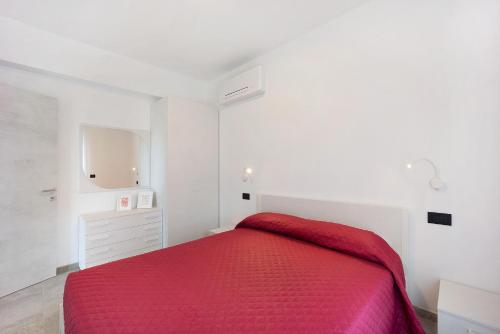 a white bedroom with a red bed and a dresser at Antichi Ricordi - Le Giare in Molino Nuovo