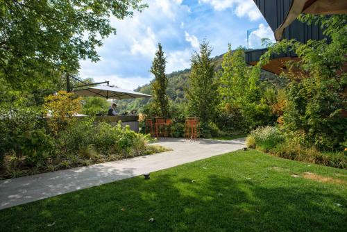 a garden with a table and chairs on a patio at Phi Hotel Piajo in Nembro