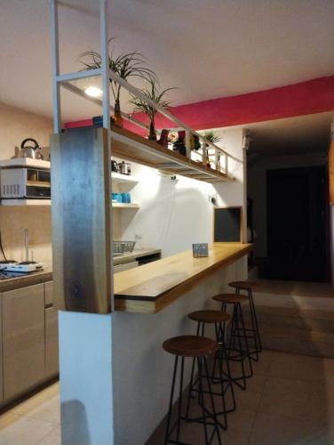 a kitchen with a counter and stools in a room at T´úubul K´iin Bed & Breakfast in Mérida