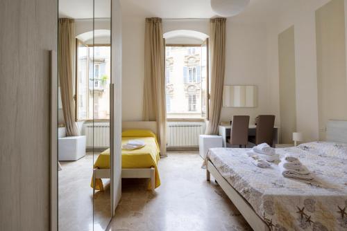 Habitación de hotel con 2 camas y espejo en Blu Sea Rooms, en La Spezia