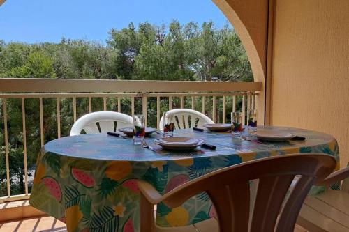 een tafel met borden en glazen op een balkon bij Bel appartement avec piscine proche des plages in Six-Fours-les-Plages