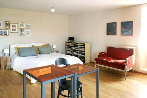 ein Schlafzimmer mit einem Bett, einem Tisch und einem Stuhl in der Unterkunft Maison de 5 chambres avec piscine privee jardin clos et wifi a Saint Lager Bressac in Saint-Lager-Bressac