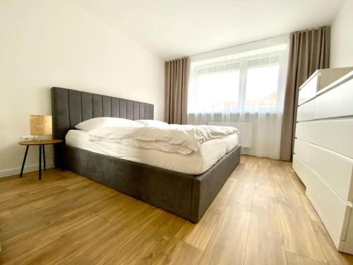 sypialnia z dużym łóżkiem i oknem w obiekcie Apartmán Samuel Prievidza w mieście Prievidza