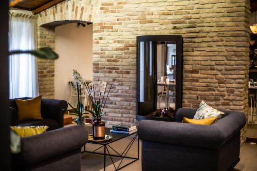 a living room with two chairs and a brick wall at The Place 217 in Rome