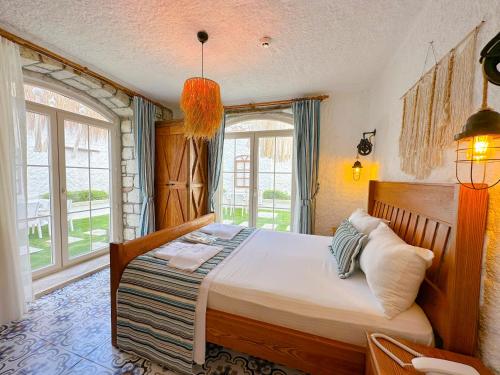 a bedroom with a bed and a large window at The Fountain Hotel in Cesme