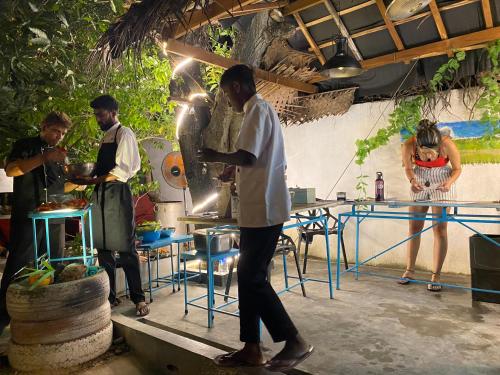 un grupo de hombres parados en una cocina preparando comida en Seconds Colombo en Colombo
