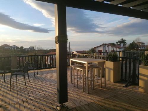 eine Terrasse mit einem Tisch und Stühlen auf einer Terrasse in der Unterkunft Tamarina in Guéthary