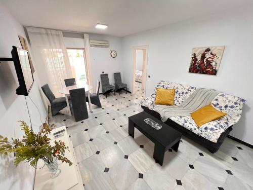 salon z kanapą i stołem w obiekcie Pedregalejo Playa, Piscina y Parking w Maladze