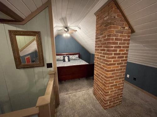 ein Schlafzimmer mit einem Bett und einer Ziegelwand in der Unterkunft ADK Game House in Au Sable Forks