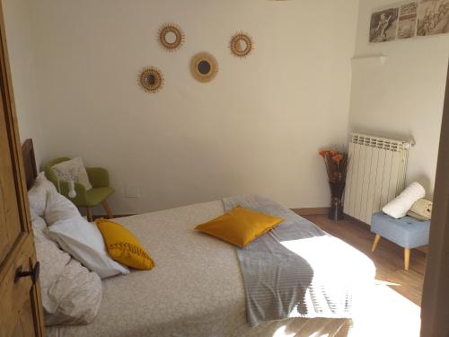 Un dormitorio con una cama con almohadas amarillas. en Deux M en Villes-sur-Auzon