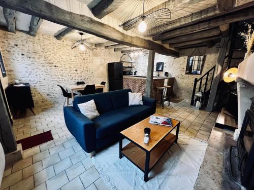ein Wohnzimmer mit einem blauen Sofa und einem Tisch in der Unterkunft Le Cottage des Chalands in Saint-Georges-sur-Cher