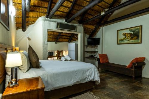 Richards Bay的住宿－Nyathi Lodge，一间卧室配有一张床、一张桌子和一把椅子