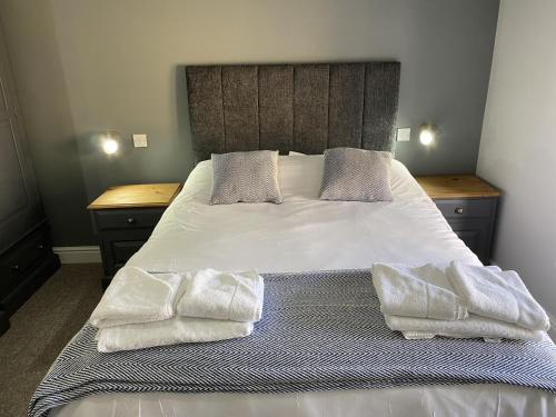 a bedroom with a bed with two towels on it at The Roade House in Northampton