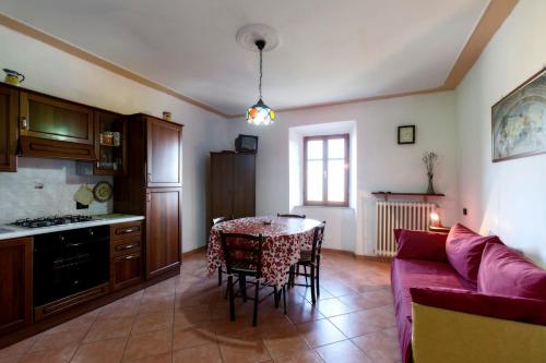 モンテカティーニ・ヴァル・ディ・チェーチナにあるI Castagniniのリビングルーム(テーブル、赤いソファ付)