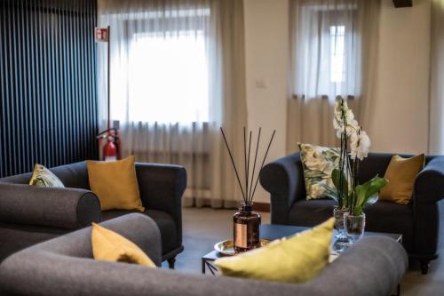 a living room with couches and a table with yellow pillows at The Place 217 in Rome